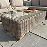 close up image of rattan glass-topped table as part of outdoor corner set