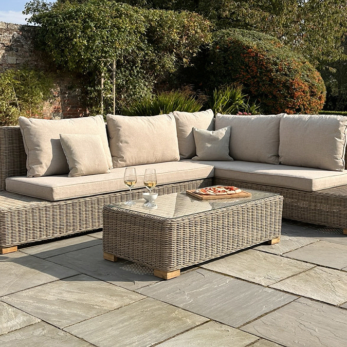 image of rattan five seat corner sofa set with matching rectangular table on flagstones of patio
