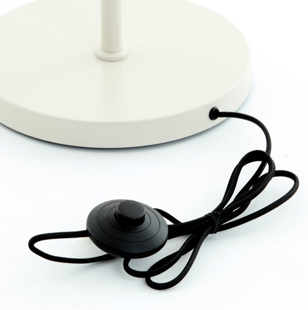 close up image of circular cream base of floor lamp with slim black cable attaching press switch