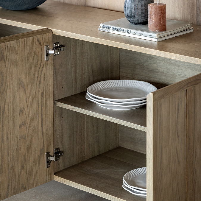close up on inside of smoked oak sideboard, showing crockery stacked neatly 