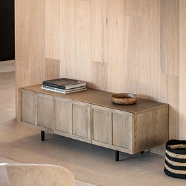 image of smoked oak panelled media unit against a dining room wall with a few coffee table books on top