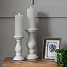 image of small and medium matt white candle holders on an oak sideboard