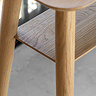 close up on light oak-effect of console table with open lower shelf and smooth round legs