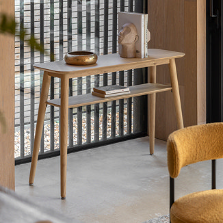 image of oak console table with shelving space, topped with stylish home accessories and books on the lower shelf
