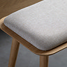 close up on cushioned fabric top of light oak bench with rounded edges