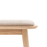 image cut out on white background of light oak bench with light grey cushioned top, close up on right hand side