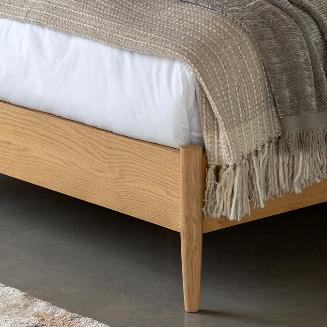 close up on foot of smooth oak bed with slim feet