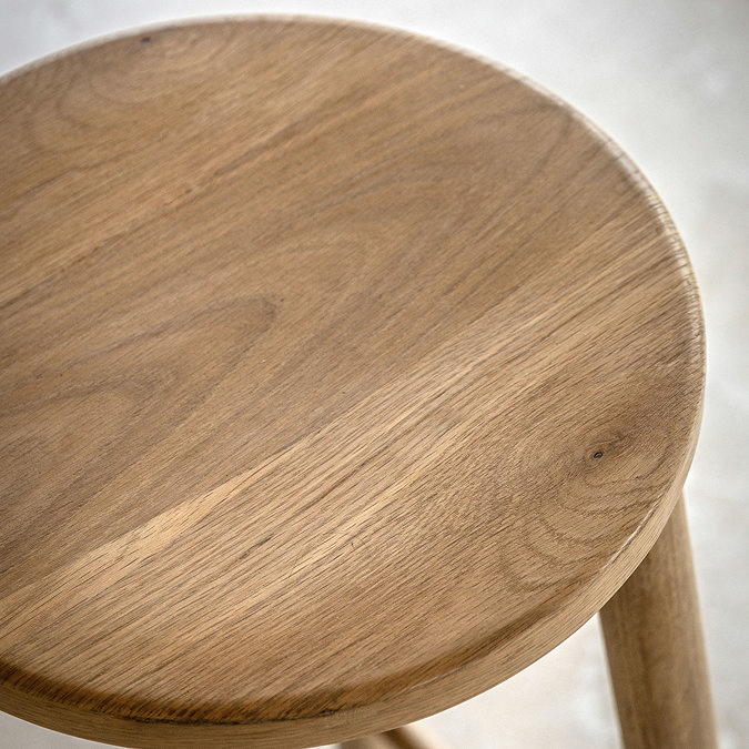 close up on round oak seat of bar stool with wood grain effect