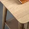 close up on wooden top of light oak bedside table with smooth curved edge