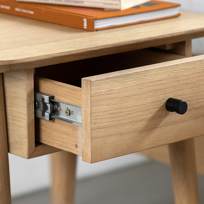 close up on drawer of light oak bedside table pulled out slightly