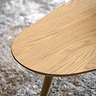 close up on round edge of light oak coffee table on soft grey rug