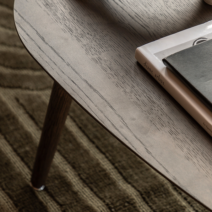 close up on smooth rounded edge of smoked oak coffee table with natural wood grain