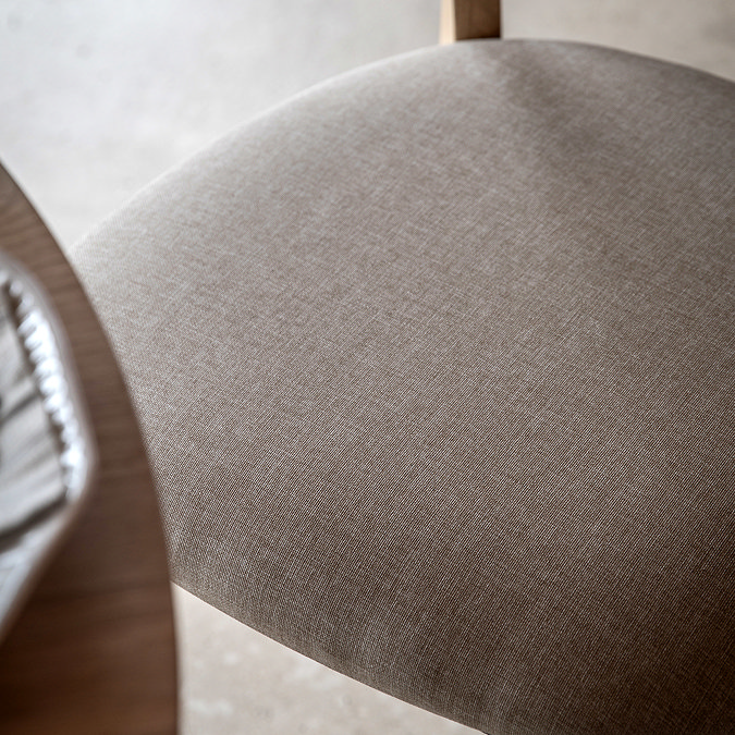 close up on light grey fabric of upholstered dining chair seat