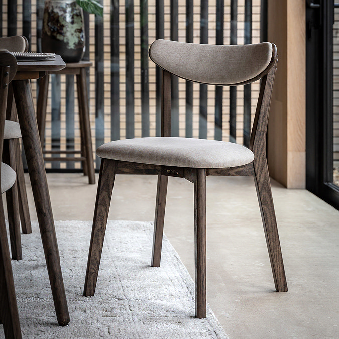 image of dark wood padded dining chair with curved backrest, on light wood flooring