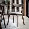 image of dark wood padded dining chair with curved backrest, on light wood flooring