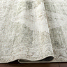 close up image of olive green and ivory vintage rug, ruched up to show its thinness