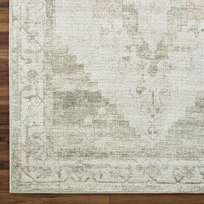 close up image of olive green and ivory patterned rug, focus on colour and texture