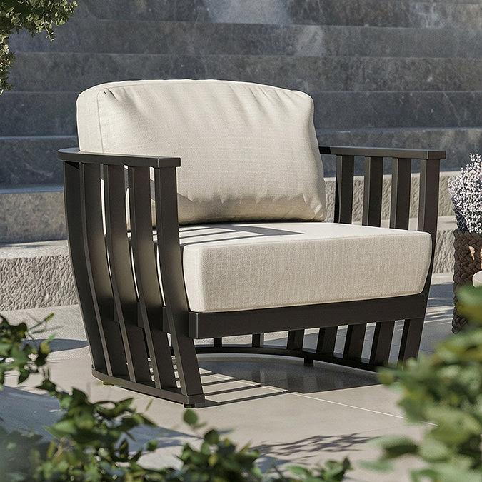 close up on rounded contemporary open frame garden armchair with plush cushions