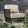 close up on rounded contemporary open frame garden armchair with plush cushions