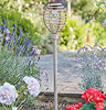 image taken during daylight of faux rattan stake light with beehive shaped top