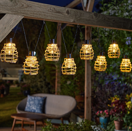 image of set of 10 honeycomb inspired string lights hanging in a garden at night