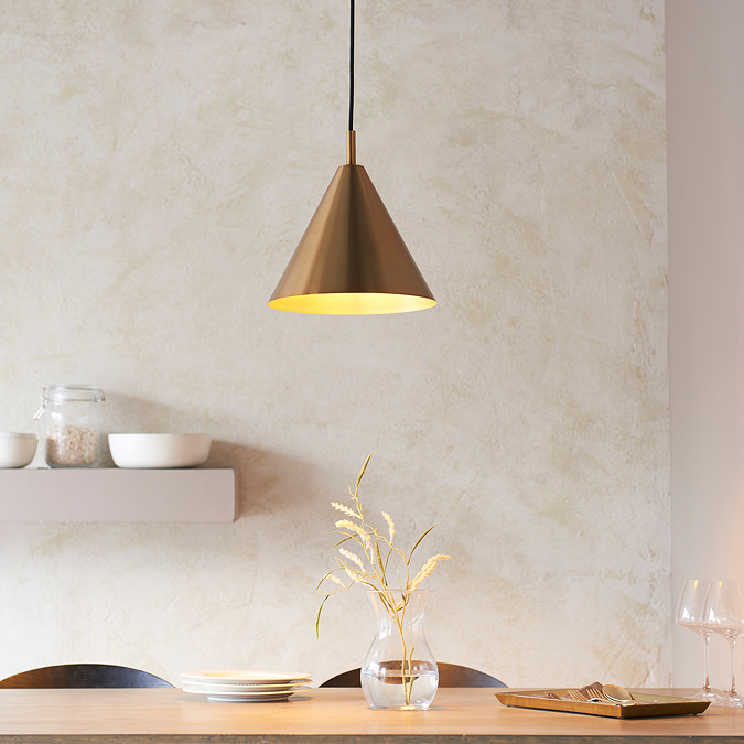 image of brass conical ceiling light casting warm glow over kitchen table