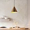 image of brass conical ceiling light casting warm glow over kitchen table