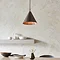 image of dark bronze ceiling light above a kitchen table, emitting warm glow
