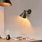 closer image of conical bronze wall light shining warm light onto dining table