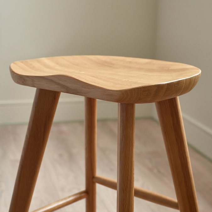 close up image of slightly waved seat of natural oak bar stool