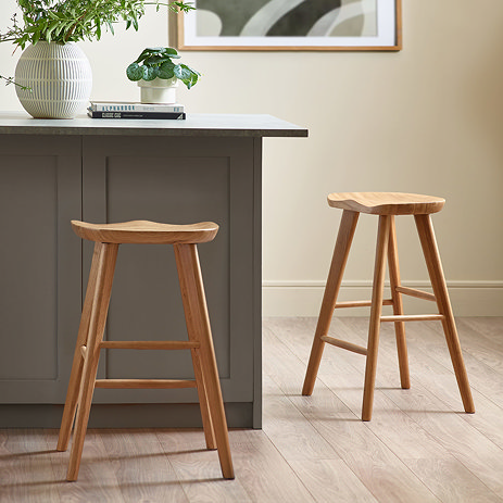 image of two natural oak stools next to a grey kitchen island on natural wooden flooring