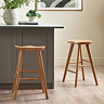 image of two natural oak stools next to a grey kitchen island on natural wooden flooring