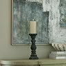 image of taupe LED pillar candle in black renaissance-column candle holder, in front of teal painting on a sideboard