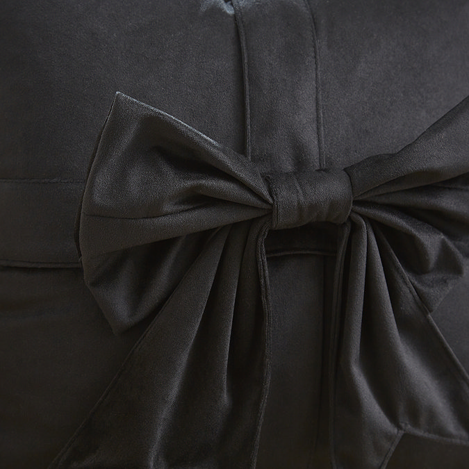 close up image of black velvet cushion with bow detail
