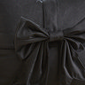 close up image of black velvet cushion with bow detail