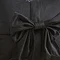 close up image of black velvet cushion with bow detail