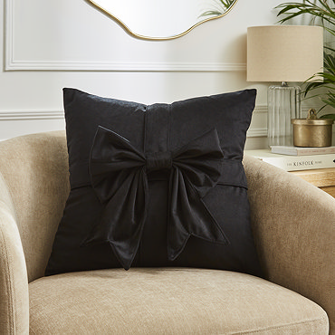 close up image of black velvet cushion with bow detail
