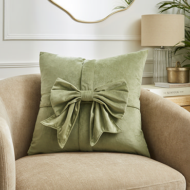 close up image of sage green velvet bow cushion