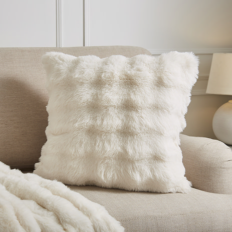 Faux fur bubble cream cushion on settee image 1