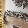 close up on a garland draped along a light oak mantlepiece