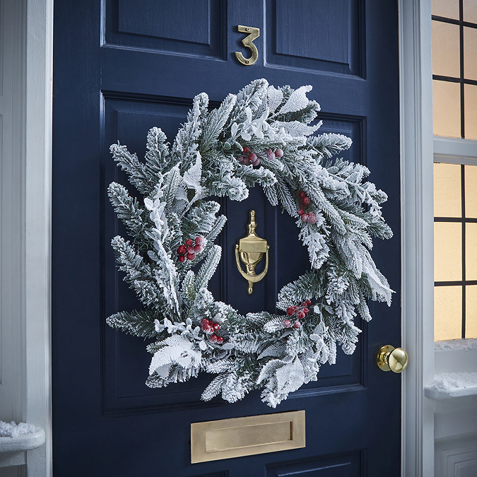 snow and berries large wreath on a navy blue front door