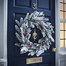 snow and berries large wreath on a navy blue front door