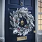 snow and berries large wreath on a navy blue front door
