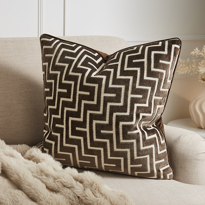 Geo cushion in chocolate brown on settee image 1