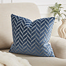 image of square blue cushion with diagonal lines, sat on cream armchair