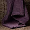 close up on plum coloured velvet throw in whicker basket