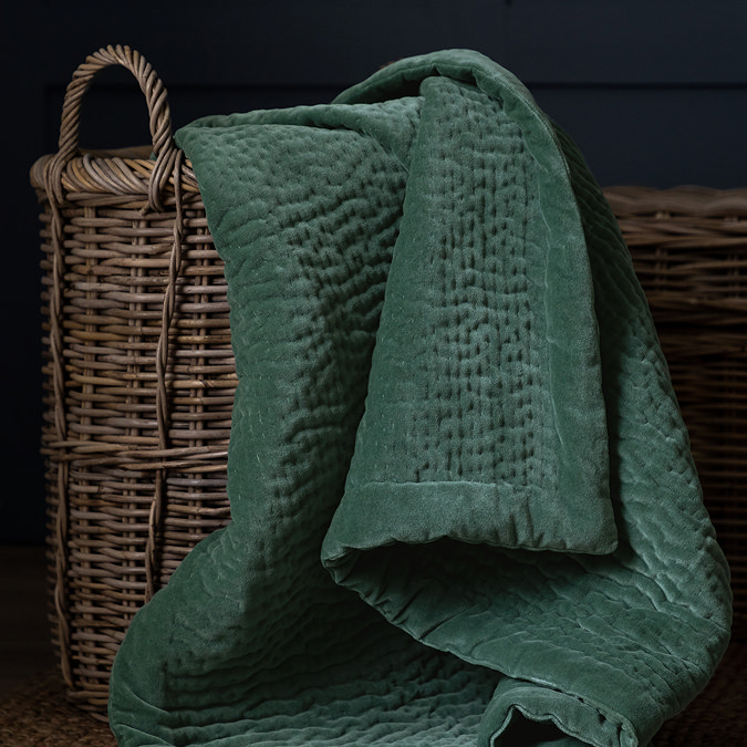 seafoam green velvet throw in whicker basket