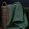 seafoam green velvet throw in whicker basket