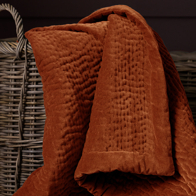 close up on sunset orange velvet throw in whicker basket