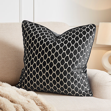 image cut out on white background of black square cushion with honeycomb pattern